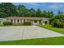Charming single-story home featuring a spacious driveway, well-maintained lawn, and mature trees at 2003 Savage Rd, Charleston, SC 29407