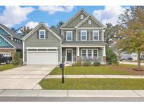 Charming two-story home with a welcoming front porch and well-manicured lawn and an attached two-car garage at 202 Center Hill Ct, Summerville, SC 29485