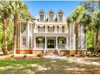Stately two-story home featuring a double porch, dormer windows, and a well-manicured lawn with palm trees at 2225 Black Oak Ct, Mount Pleasant, SC 29466