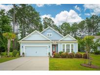 Charming, light blue single Gathering home with well-manicured landscaping and a two-car garage at 259 Camber Rd, Huger, SC 29450
