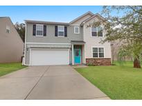 Two-story home featuring a two-car garage, a bright blue front door, and well-maintained landscaping at 281 Decatur Dr, Summerville, SC 29486