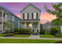 Charming two-story home with a welcoming front porch and manicured landscaping at sunset at 3 Clearblue Loop, Summerville, SC 29486