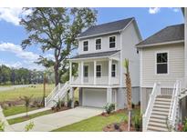 Charming two-story home with a white garage, inviting porch, and meticulously landscaped front yard at 3029 Robeson Trce, Johns Island, SC 29455