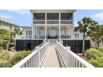 Stunning two-story beach house with multiple balconies, a walkway, and lush tropical landscaping at 3126-B Palmetto Blvd # 4, Edisto Island, SC 29438