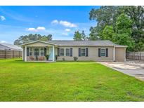 Charming single-story home with a well-manicured lawn, a covered porch, and neutral siding at 337 Price St, Goose Creek, SC 29445