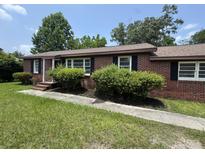 Charming single-story brick home featuring well-maintained landscaping, a covered porch, and classic black shutters at 36 Guerry Cir, Goose Creek, SC 29445