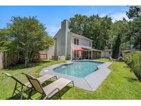 Inviting backyard features a sparkling pool, lounge chairs and screened in porch; perfect for relaxation and entertaining at 3813 Battleview Ct, North Charleston, SC 29420