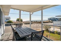 Inviting outdoor dining space with ocean views from covered porch at 405 Palmetto Blvd, Edisto Island, SC 29438