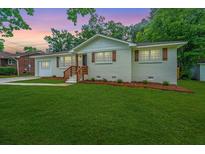 Charming single-story home features a well-manicured lawn and inviting front porch at 4233 Oakridge Dr, North Charleston, SC 29418