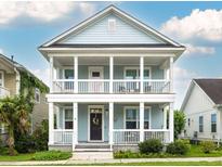 Charming two-story home with a double porch, light blue siding, and white trim at 4953 W Liberty Park Cir, North Charleston, SC 29405