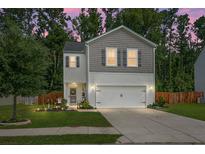 Charming two-story home with a well-manicured lawn and a two-car garage, situated beneath a captivating dusk sky at 508 Glady Rd, Moncks Corner, SC 29461