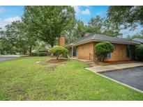 Charming brick home with a well-manicured lawn and mature trees providing ample shade at 58 Indigo Ln, Goose Creek, SC 29445