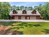 Spacious three-car garage with upper level framed by lush greenery at 6840 Early Jersey Rd, Meggett, SC 29449