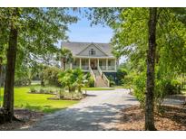 Charming two-story home with a welcoming front porch and landscaped front yard at 8964 Palmetto Rd, Edisto Island, SC 29438