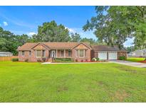 Charming brick home with well-manicured lawn and a convenient attached three-car garage at 1023 Striper Ave, Moncks Corner, SC 29461
