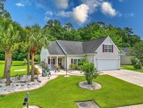 Charming single-story home with a manicured lawn, palm trees, and well-maintained landscaping at 107 Oakbluff Rd, Summerville, SC 29485
