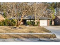 Charming single-story brick home featuring a well-maintained yard and attached garage at 113 Surrey Dr, Summerville, SC 29486