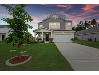 Charming two-story home features a well-manicured lawn and a two-car garage at 123 Lyra Ln, Summerville, SC 29486