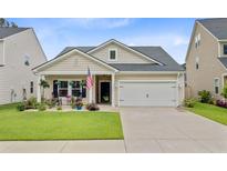 Charming single-story home with a well-manicured lawn, attached two-car garage, and quaint porch at 135 Cypress Preserve Blvd, Moncks Corner, SC 29461