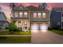 Charming two-story home featuring a welcoming front porch and a convenient two-car garage at 154 Calm Water Way, Summerville, SC 29486