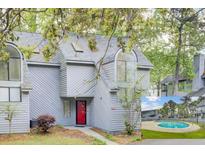 Grey home with a bright red door, an inset of a swimming pool, and mature trees at 2159 Spoleto Ln # E, North Charleston, SC 29406