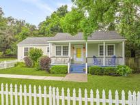 Charming single-story home with a welcoming front porch, a white picket fence, and manicured lawn at 2343 Herndon Dr, Charleston, SC 29414