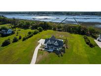 Expansive modern farmhouse with a manicured lawn and private pier overlooking the marshlands at 2621 Anchor Watch Dr, Wadmalaw Island, SC 29487