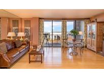 Bright living room with hardwood floors, a leather sofa, and a balcony with a view at 330 Concord St # 8E, Charleston, SC 29401