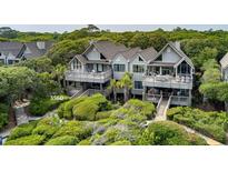 Stunning two-story home with multiple decks, lush landscaping, and private boardwalk at 3560 Shipwatch Rd, Kiawah Island, SC 29455