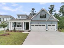 Charming, light blue two-story home featuring a two-car garage, front porch and manicured lawn at 395 Wappoo Trace Ln, Summerville, SC 29486