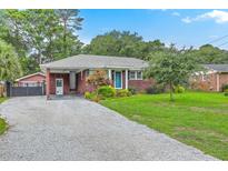 Charming brick home featuring a gravel driveway, carport, and landscaped front yard at 4729 Lang Ridge Dr, North Charleston, SC 29405
