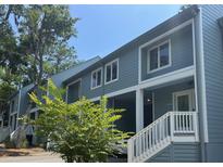 Charming two-story condo featuring inviting entrances with white railings and verdant landscaping at 491 Sea Cloud Cir, Edisto Island, SC 29438