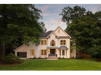 Beautiful two-story white brick home featuring a well-manicured lawn, large trees, and eye-catching architectural details at 499 Lackland Ct, Mount Pleasant, SC 29464