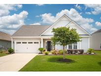 Charming single-story home with a well-manicured lawn and an attached two-car garage and inviting curb appeal at 516 Tidewater Chase Ln, Summerville, SC 29486
