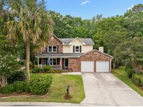 Inviting two-story home with brick facade, front porch, manicured lawn, and two-car garage at 5488 Altamaha Dr, North Charleston, SC 29420