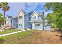 Charming blue two-story townhome featuring shingle and siding accents, well-manicured landscaping, and a welcoming entryway at 851 Sandlake Dr # D, Mount Pleasant, SC 29464