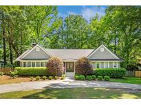 Charming home featuring a lush, landscaped front yard with mature trees and a circular driveway at 1061 Law Ln, Mount Pleasant, SC 29464