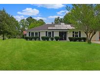 Charming single-story home with solar panels, lush lawn and manicured shrubs at 1101 Stuart Dr, Moncks Corner, SC 29461