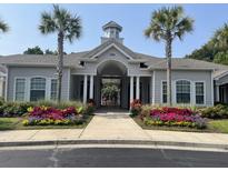 Beautiful clubhouse exterior featuring palm trees and colorful landscaping at 1300 Park West Blvd # 822, Mount Pleasant, SC 29466