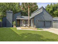 Charming modern home with gray siding, a two-car garage and a beautiful palm tree in the front yard at 1368 Little David Court Ct, Charleston, SC 29412