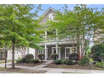 Charming two-story home featuring a spacious front porch and beautifully landscaped front yard with mature trees at 1523 Nautical Chart Dr, Charleston, SC 29414