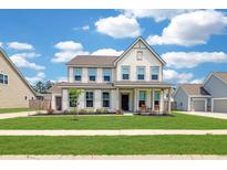 Charming two-story home featuring a well-manicured lawn, inviting front porch, and classic architectural details at 2064 Parish House Cir, Johns Island, SC 29455