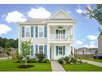 Charming two-story home featuring a double porch, blue shutters, and lush landscaping at 2267 Kemmerlin St, Johns Island, SC 29455