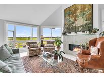 Bright living room features a vaulted ceiling, fireplace, and picturesque views at 250 Little Oak Island Dr, Folly Beach, SC 29439