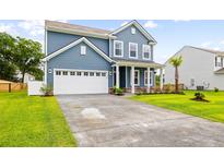 Charming two-story home showcasing manicured lawn, blue siding, and a well-lit two car garage and driveway at 3010 Grinnell St, Johns Island, SC 29455