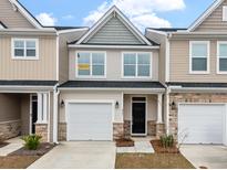 Charming townhome with attached garage, stone accents, and neutral siding provides excellent curb appeal at 422 Duskywing Dr, Goose Creek, SC 29445