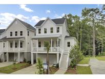 Charming two-story home with white siding, covered porch, and well-manicured landscaping at 615 Du Bois Dr, Johns Island, SC 29455
