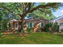 Lovely brick home featuring a big shade tree, green lawn, and charming curb appeal at 624 Atlantic St, Mount Pleasant, SC 29464