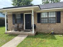 Charming brick home with a cozy front porch perfect for relaxing and enjoying the neighborhood views at 7709 Suzanne Dr, North Charleston, SC 29418