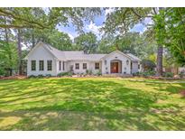 Charming home featuring a well-manicured lawn and beautiful landscape surrounded by mature trees offering a serene setting at 974 Cliffwood Dr, Mount Pleasant, SC 29464